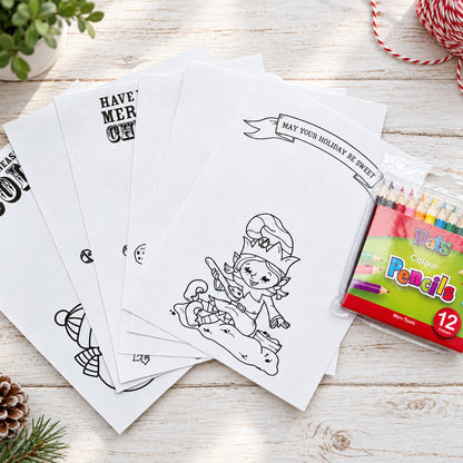 A set of white Christmas-themed coloring pages with black line art, fanned out on a light wood surface next to a package of 12 colour pencils.