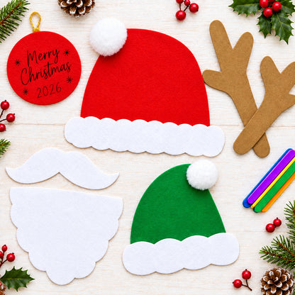 Felt Christmas craft cutouts on a light wood background, including a red Santa hat with white trim, a green Santa hat with white trim, brown reindeer antlers, a white mustache, a round red tag reading 'Merry Christmas 2021', and colorful craft sticks.