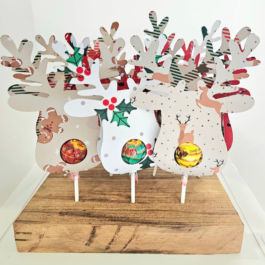Decorative reindeer-shaped toppers with colorful designs on a wooden stand.