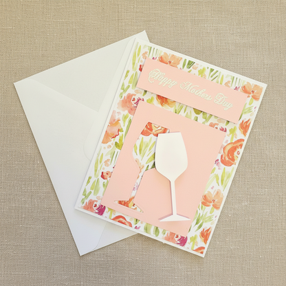 Greeting card with floral design and wine glass silhouette on a beige textured background